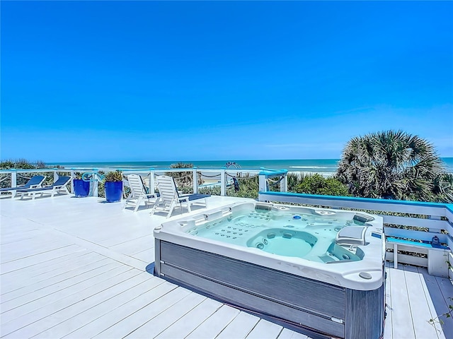 deck with a water view and hot tub deck surround
