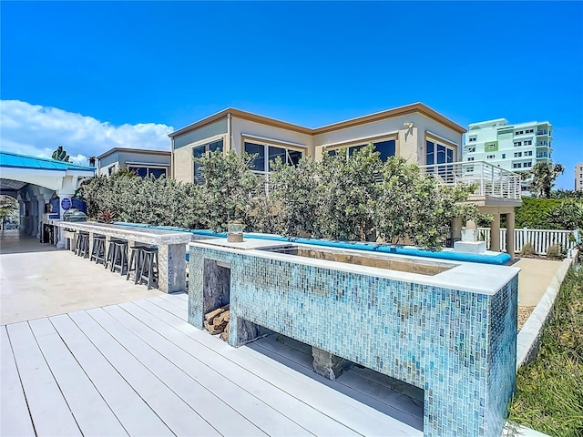 view of pool featuring a wooden deck and outdoor dry bar