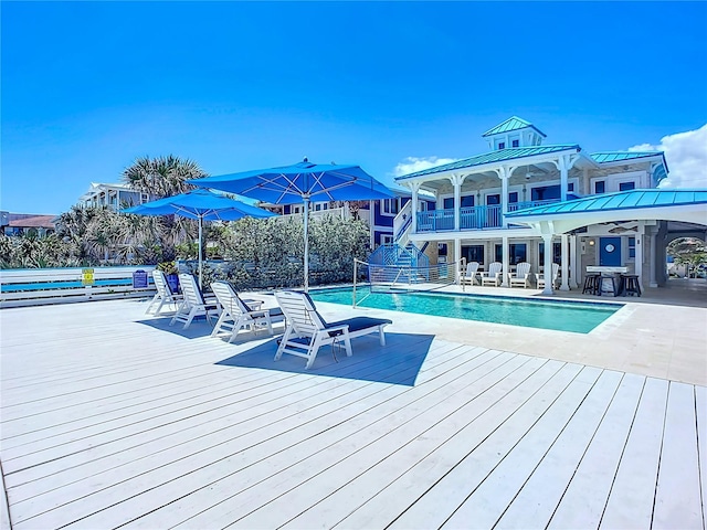 view of pool featuring a patio and a wooden deck