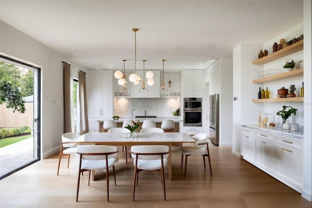 dining room with sink and light hardwood / wood-style flooring