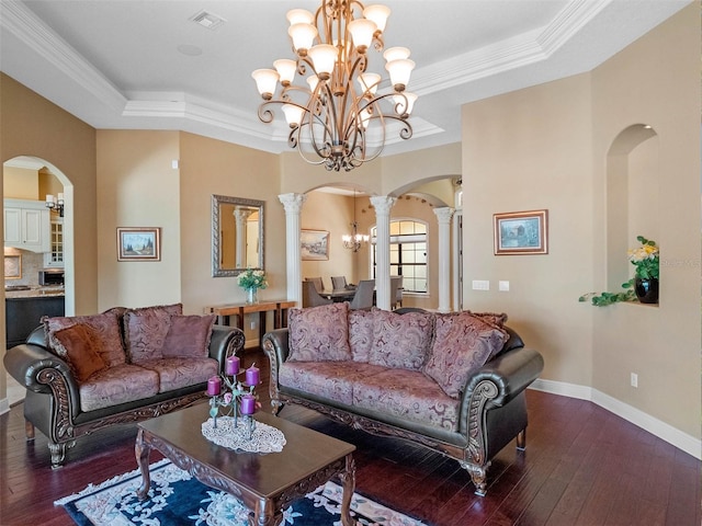 living area with arched walkways, hardwood / wood-style flooring, visible vents, and a raised ceiling