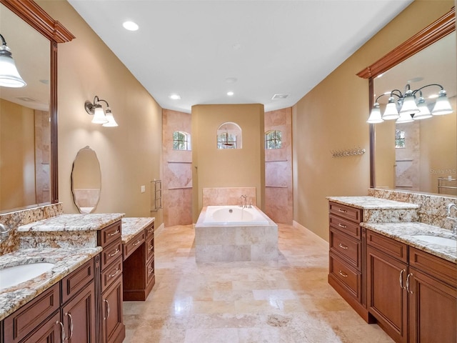 bathroom with visible vents, two vanities, a sink, and a bath