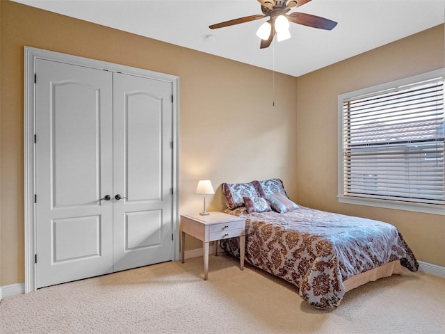 carpeted bedroom featuring baseboards, a ceiling fan, and a closet