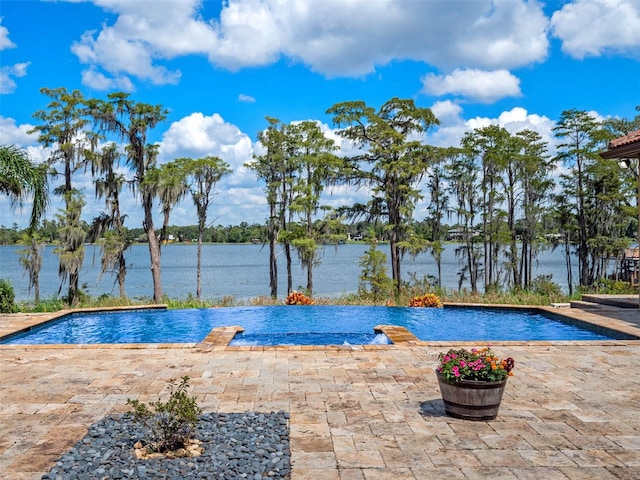 pool featuring a water view and a patio area