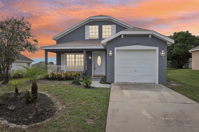 view of front of property featuring stucco siding, driveway, covered porch, a front yard, and a garage