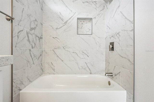 bathroom featuring tiled shower / bath