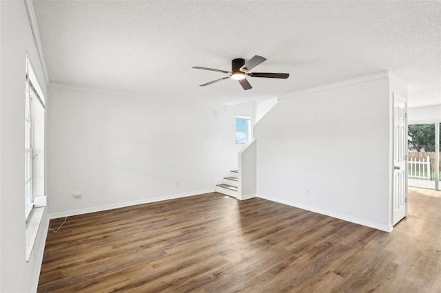 unfurnished room featuring ceiling fan, ornamental molding, dark hardwood / wood-style flooring, and a textured ceiling