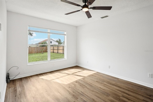 unfurnished room featuring light wood-type flooring, ceiling fan, and a textured ceiling