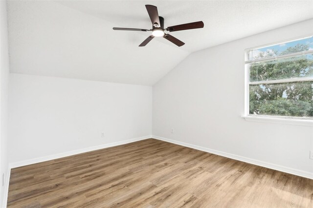 additional living space featuring vaulted ceiling, wood-type flooring, and ceiling fan