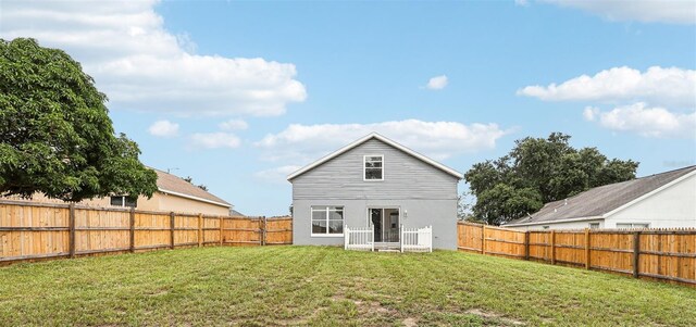 rear view of property featuring a yard