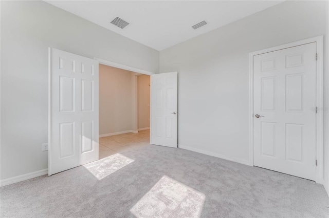 unfurnished bedroom featuring baseboards, visible vents, and carpet floors