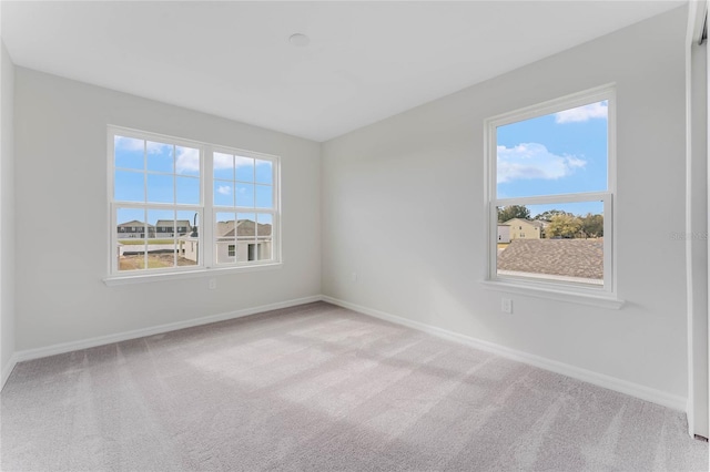 carpeted empty room featuring baseboards