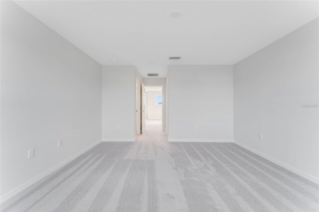 unfurnished room featuring light carpet