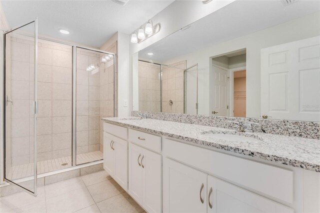 bathroom with vanity, tile patterned floors, and a shower with door