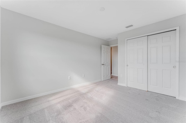 unfurnished bedroom featuring a closet, visible vents, carpet, and baseboards