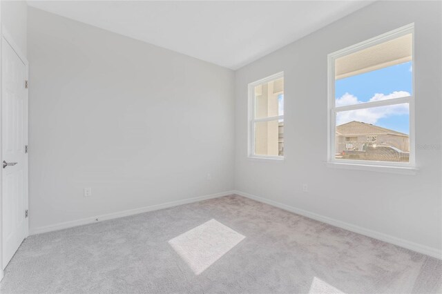 unfurnished room featuring light colored carpet