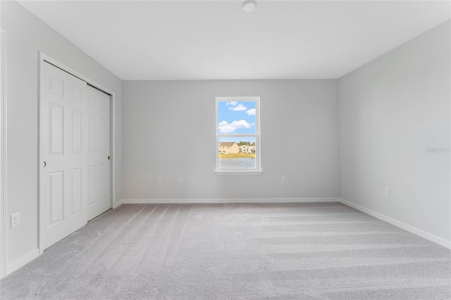 unfurnished bedroom featuring a closet and light carpet