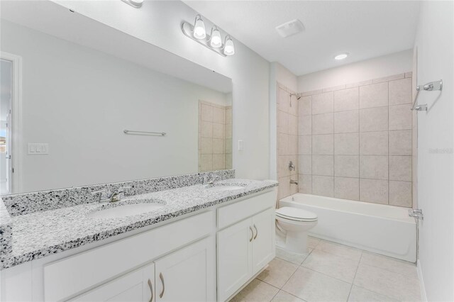 bathroom featuring double vanity, a sink, shower / bath combination, tile patterned floors, and toilet