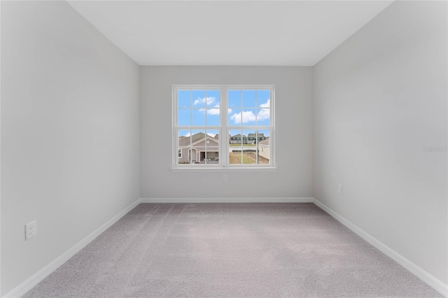 carpeted empty room featuring baseboards