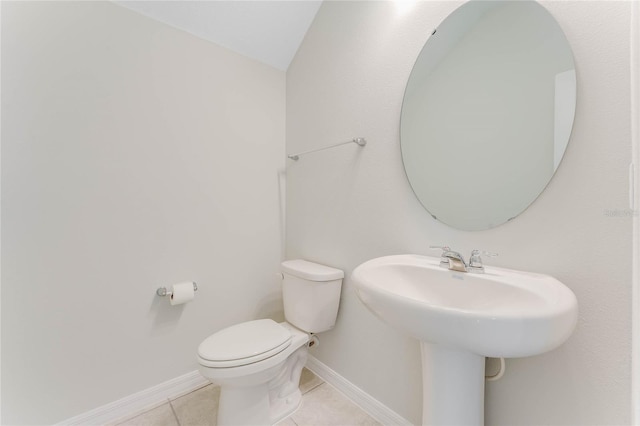 bathroom with vaulted ceiling, toilet, and tile patterned floors