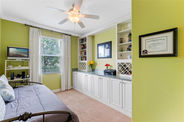 carpeted bedroom with ceiling fan and ornamental molding