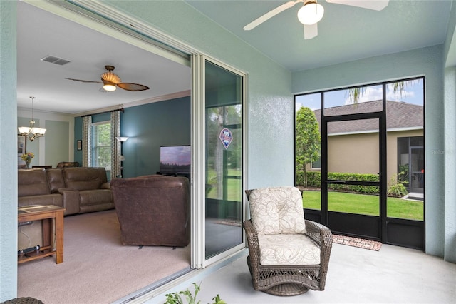 sunroom / solarium featuring ceiling fan with notable chandelier and plenty of natural light