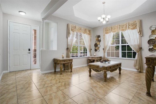 entrance foyer with a chandelier, light tile patterned floors, and a raised ceiling