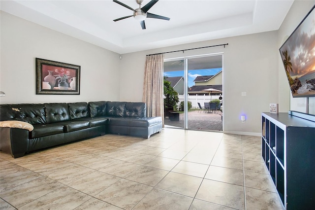 living room featuring ceiling fan and a tray ceiling