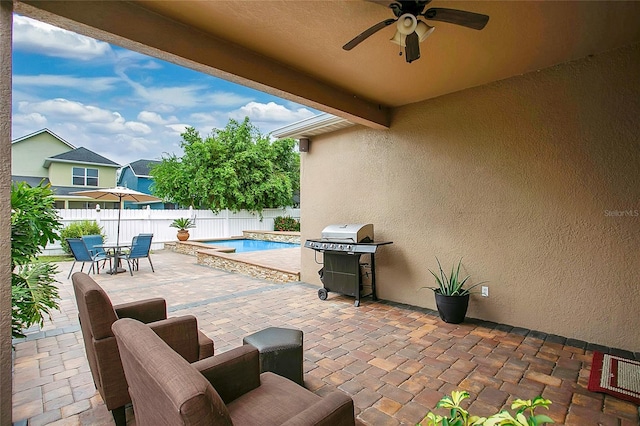 view of patio with a fenced in pool, area for grilling, and ceiling fan