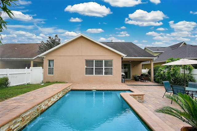 back of property with a patio, pool water feature, and a fenced in pool