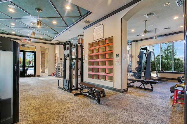 exercise room featuring crown molding, carpet floors, and plenty of natural light