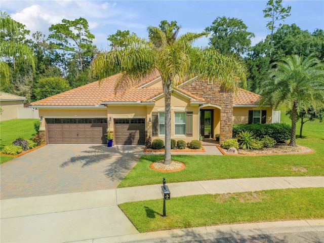 mediterranean / spanish-style home featuring a garage and a front yard