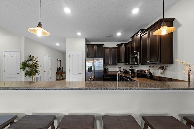 kitchen with dark brown cabinetry, appliances with stainless steel finishes, hanging light fixtures, and kitchen peninsula