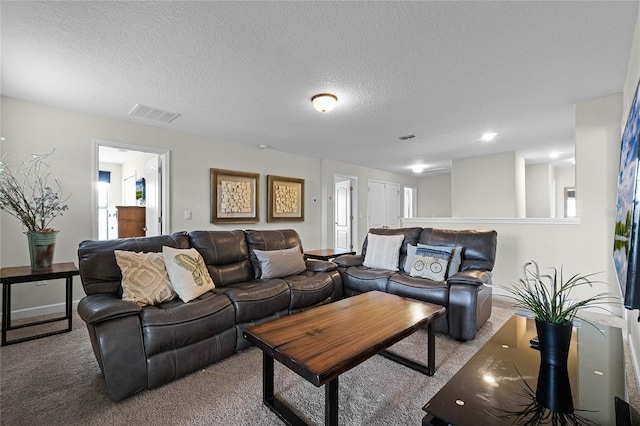 living room with a textured ceiling and carpet