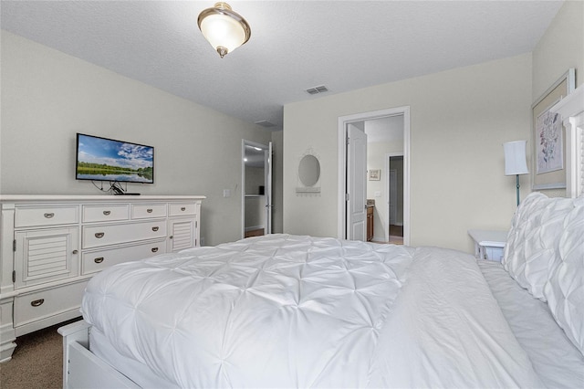 carpeted bedroom featuring connected bathroom and a textured ceiling