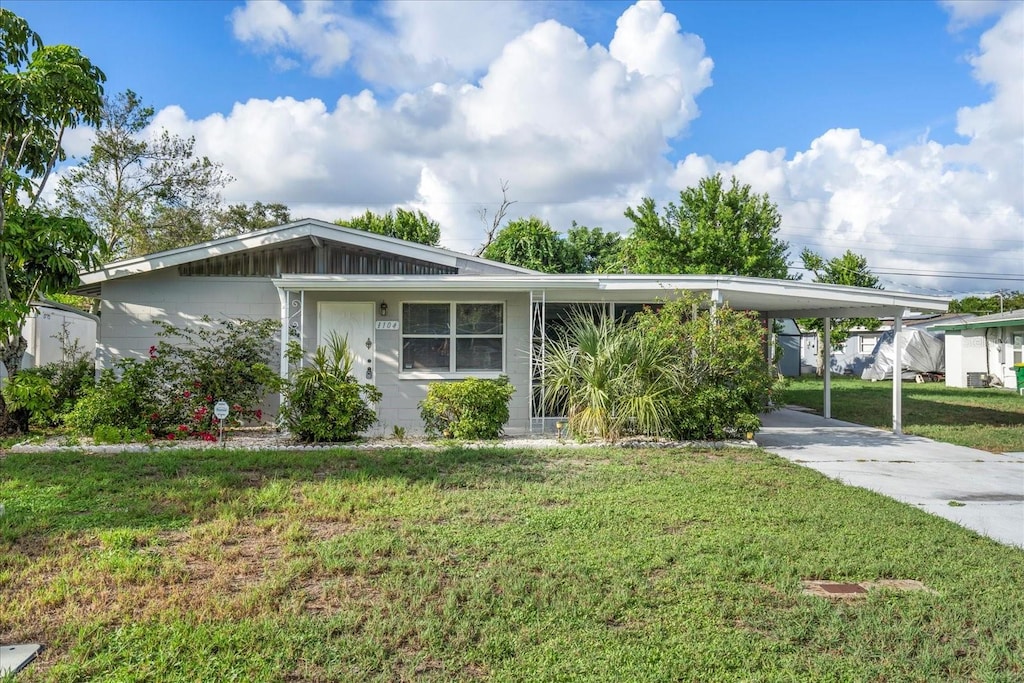 ranch-style house with a carport and a front lawn