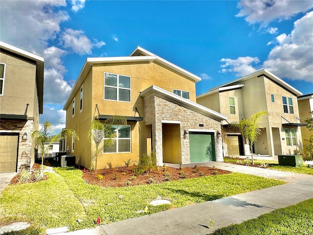 view of front facade with a front yard, a garage, and central AC unit