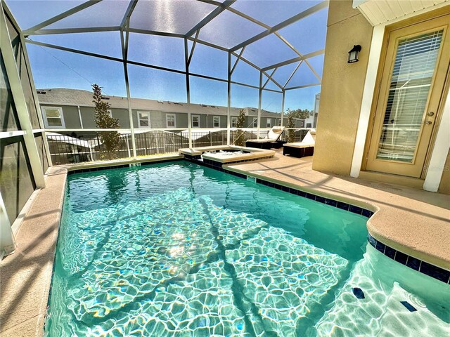 view of swimming pool featuring a patio area and glass enclosure