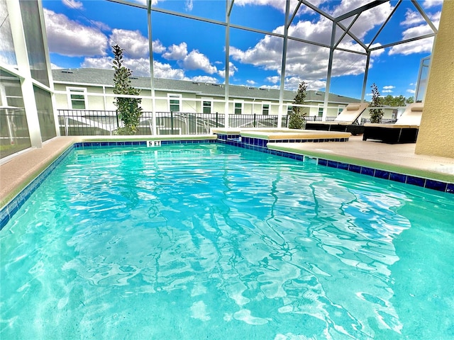 view of swimming pool featuring a patio area and a lanai