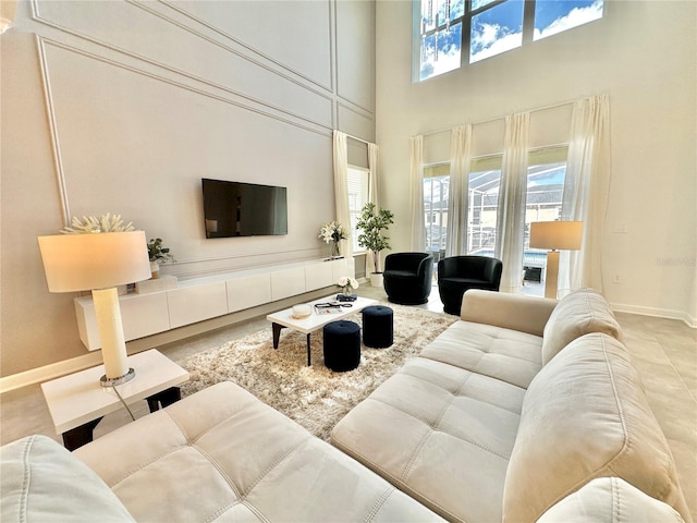 tiled living room featuring plenty of natural light and a towering ceiling