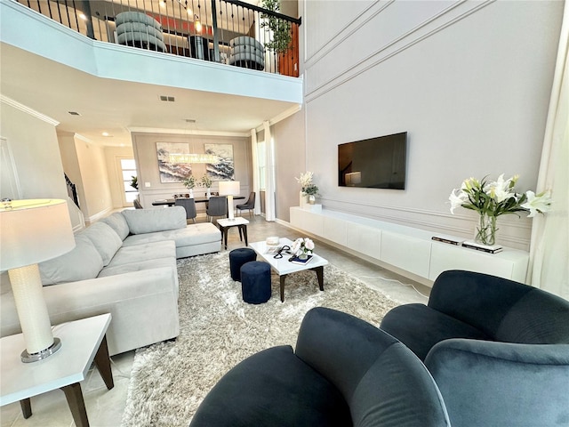 living room featuring crown molding, a towering ceiling, and light tile patterned floors