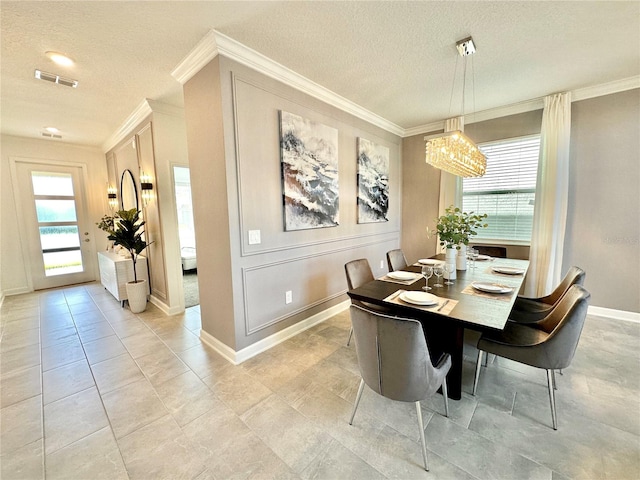 dining room featuring a textured ceiling, crown molding, and an inviting chandelier