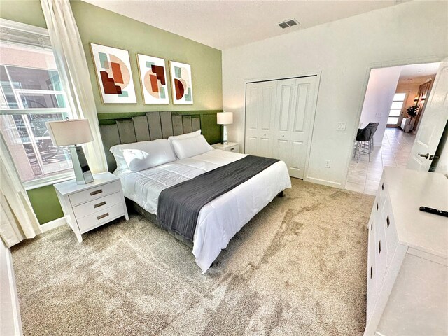 bedroom featuring a closet and light carpet