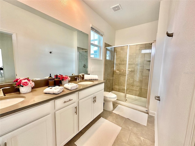 bathroom with tile patterned flooring, toilet, a shower with door, and vanity