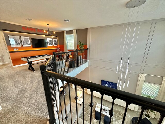 stairs featuring carpet flooring and a notable chandelier