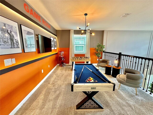 playroom with pool table, a chandelier, a textured ceiling, and carpet floors