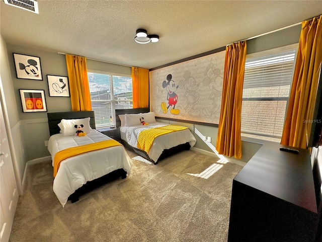 bedroom with a textured ceiling and carpet flooring