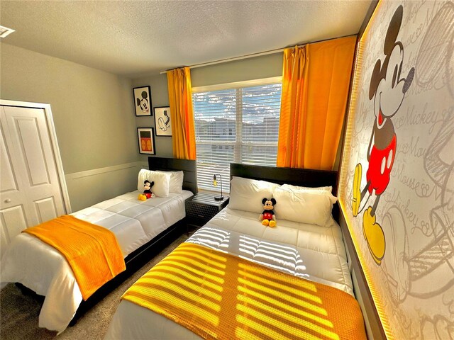 carpeted bedroom featuring a textured ceiling and a closet