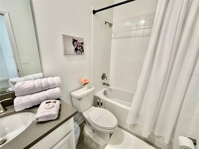 full bathroom featuring toilet, shower / tub combo with curtain, and vanity