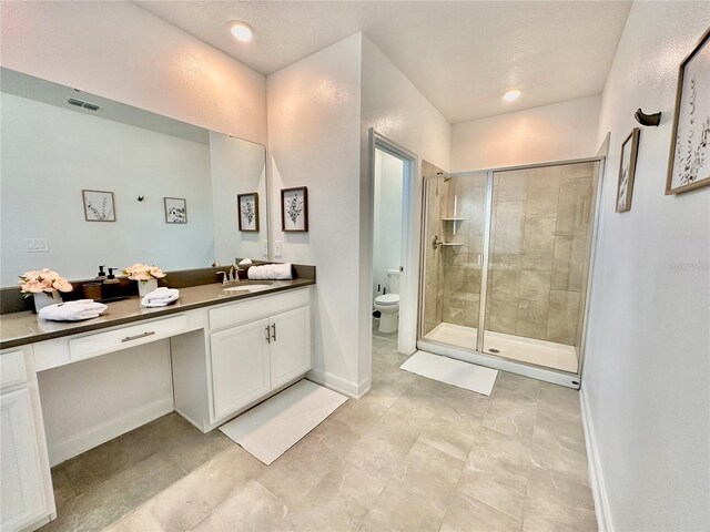 bathroom with vanity, toilet, and a shower with shower door